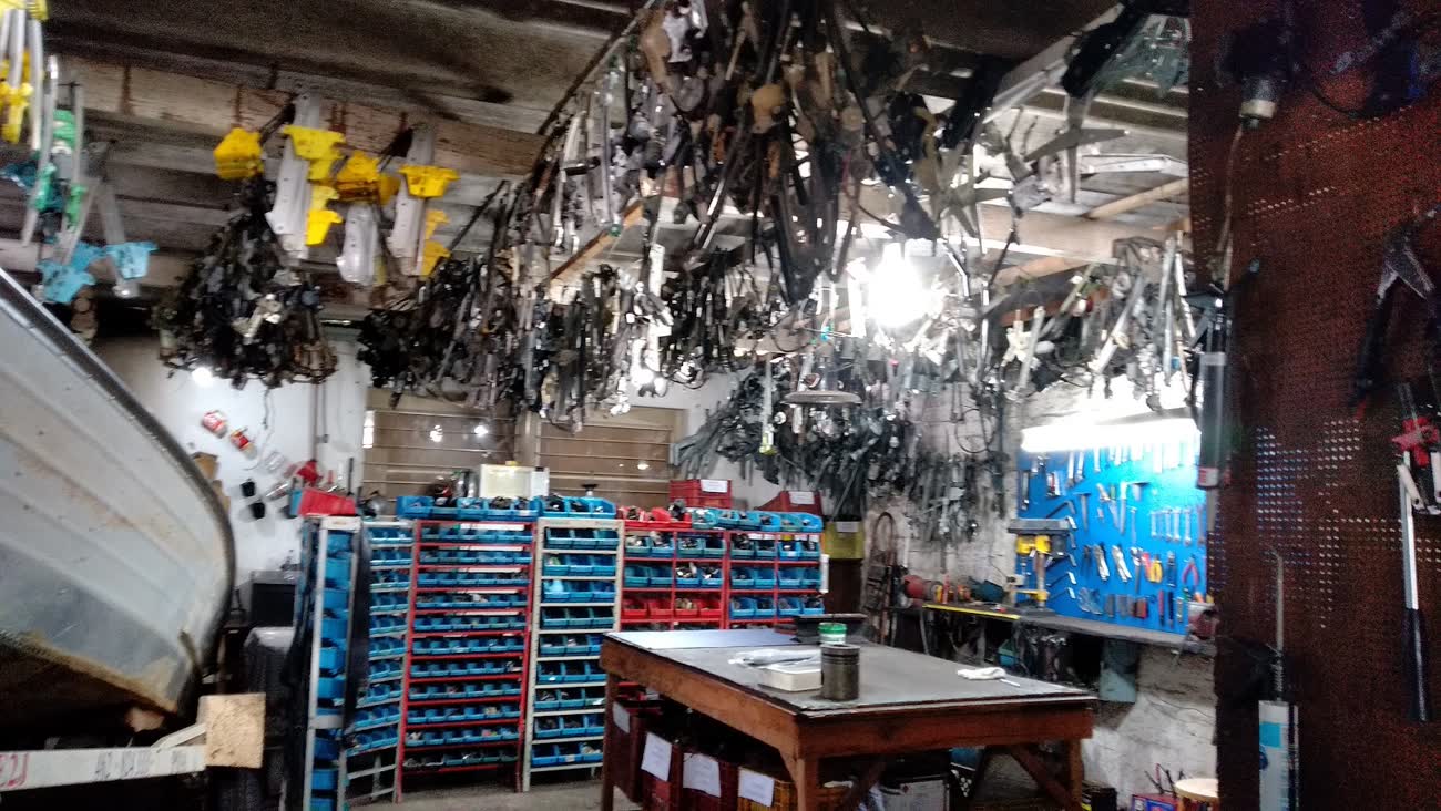 Parede da oficina com centenas de máquinas de vidro e peças de porta organizadas por modelo